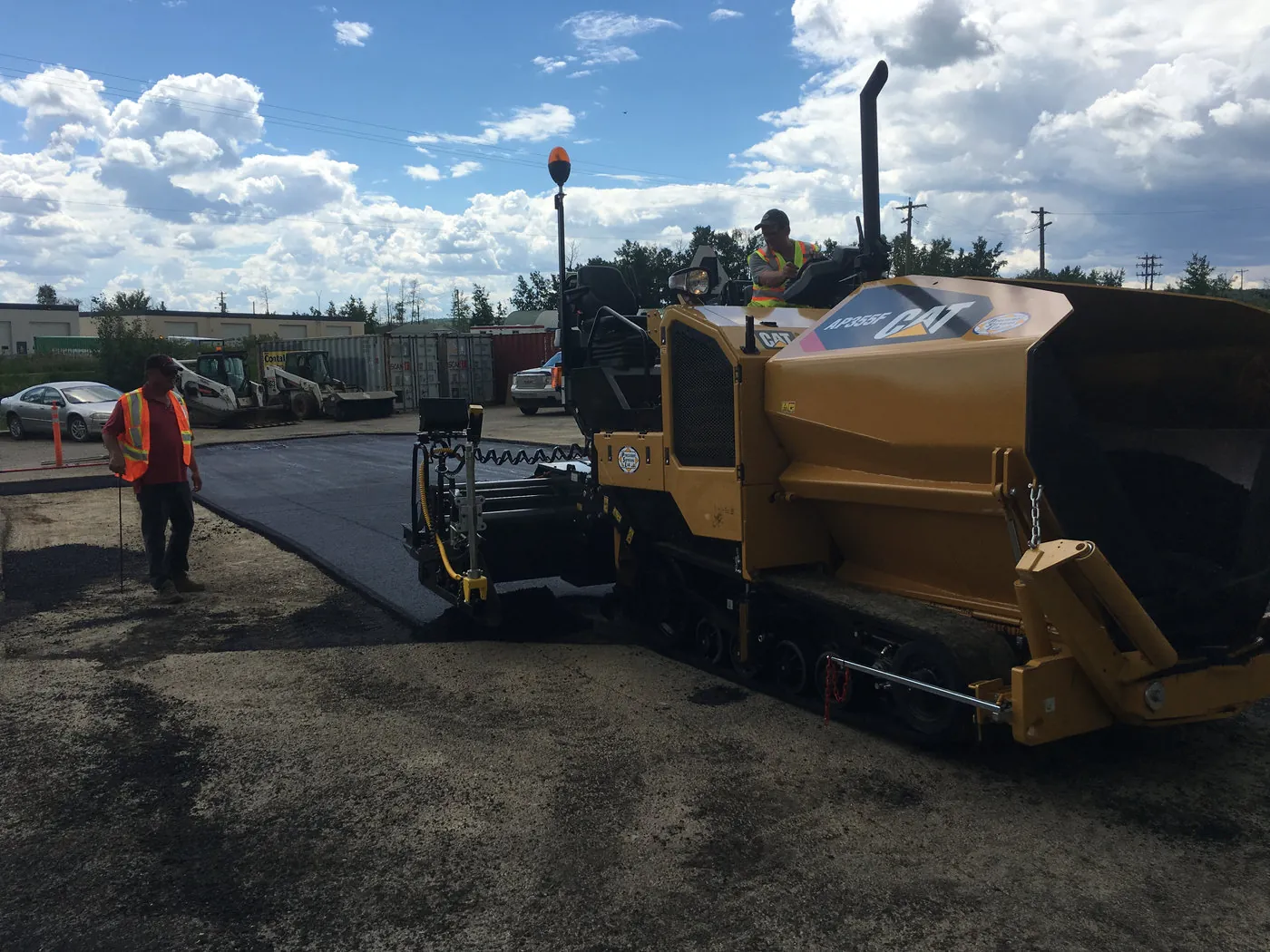 Asphalt paver laying a hot mix mat on a Northern Alberta road